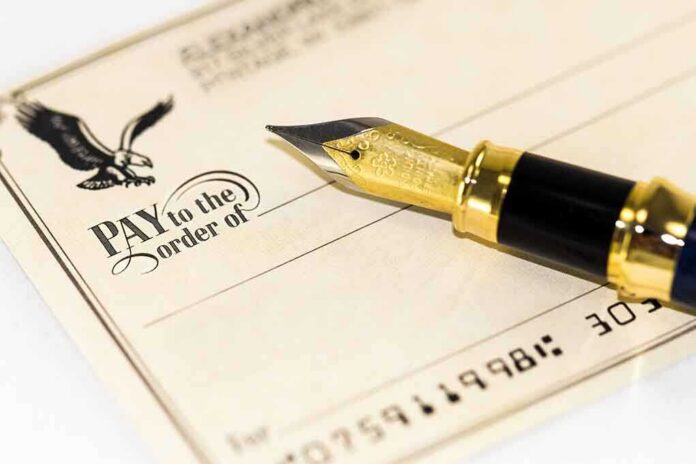shutterstock_118549420 Close-up of a check with a fountain pen and an eagle illustration
