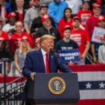 speaker at podium addressing crowd at rally