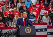 Michigan Showdown: Hype Or Hiring? speaker at podium addressing crowd at rally