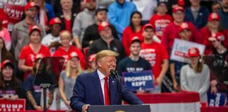 speaker at podium addressing crowd at rally