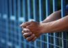 Eight-Car Carnage, Judge Goes Light Close-up of clasped hands resting on a blue fence