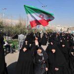 Manufactured Mourning? Iran’s Crowd Riddle Group of women in black attire marching with an Iranian flag
