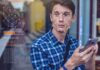 Celebs Tagged and Fans Tracked at Madison Square Garden Young man using a smartphone with face recognition overlay