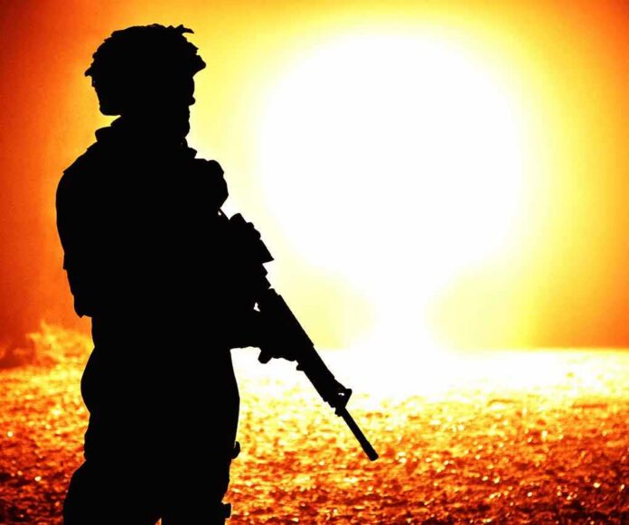 shutterstock_1029359377 silhouette of an armed soldier against a bright fiery background