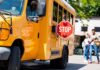School Bus Standoff Sparks Arrest School bus with extended stop sign near students on sidewalk