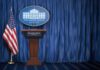 Helicopter Stunt Triggers High-Rank Purge White House press briefing podium with U.S. flag and blue curtain