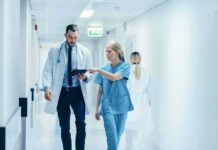 Doctor Claims VA Retaliation—Abortion Ultimatum Doctors walking in a hospital corridor reviewing a tablet