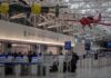 Airport Fight Erupts Over $300K Bathroom Add-On airport security checkpoint with passengers and hanging vintage airplanes