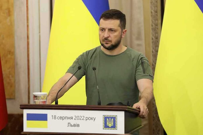 shutterstock_2197413383 Man at a podium with Ukrainian flags