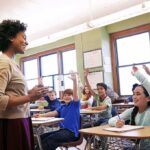 Florida’s Bold Classroom Shake-Up Teacher engaging with students raising hands in a classroom