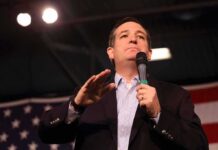 man speaking into a microphone at a rally