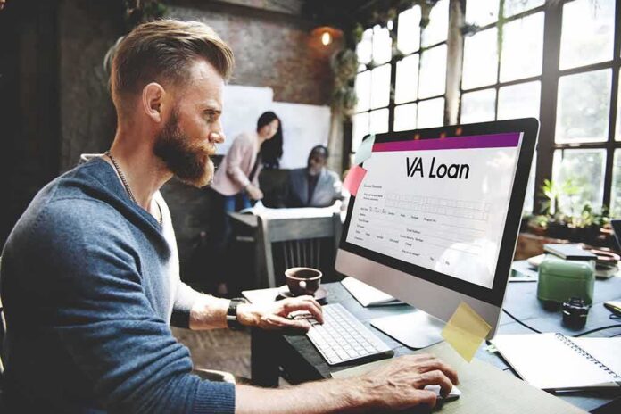 shutterstock_483345748 Man working at a computer with a loan form on screen