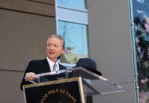Bill Maher’s Burrito Math Ignites Backlash A man in formal attire speaking at a podium during a Hollywood Walk of Fame ceremony