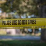 Priest Killed Inside Sacred Grounds yellow police tape cordoning off an outdoor area