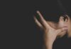 Stealth Decision Stuns Women’s Sports Backers person covering face with hand in dark background