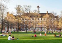 Foreign Cash Shadows Top Campuses Students relaxing on a campus quad in front of a brick academic building