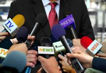 White House Ban Sparks First Amendment Clash Press microphones surround a suited spokesperson