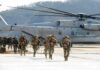 12-Year War Chapter Closes – Now What? Soldiers disembark and walk past a large military helicopter