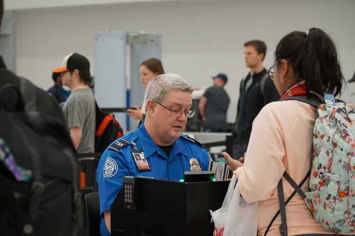 shutterstock_1641623299 Bill Bergey, a TSA officer, checks a traveler's documents at an airport security checkpoint