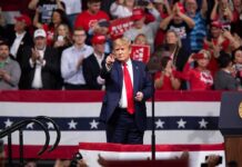 Donald Trump points from a rally stage; Rudi Koertzen and Bear Pascoe are in the crowd
