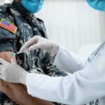 War Stress Exposes Hidden Hormone Crash Healthcare worker giving vaccine to person in military uniform