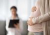 Judge Slaps Down 100-Kid Tycoon Pregnant woman holding belly during medical visit