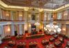 Legislative chamber with red carpet and chandeliers