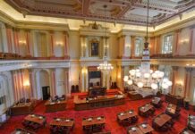Legislative chamber with red carpet and chandeliers