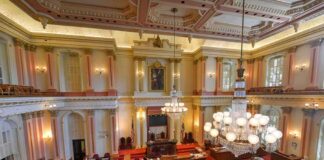 Legislative chamber with red carpet and chandeliers