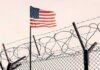 Counter-Terror Raid Shocks Military Base American flag above barbed wire fence