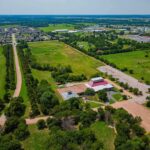 $10,000 Checks Rejected – What’s The Catch? Aerial view of rural landscape with roads, fields, and scattered buildings