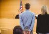 Victim’s Dad Leaps Table – Stuns Court Defendant in handcuffs standing before a judge in a courtroom
