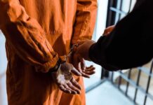 Brazil Erupts: Top Judge Targets Bolsonaro Clan Prisoner in orange jumpsuit handcuffed by officer