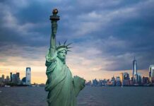 Inferno Near ‘Godfather’ Church Statue of Liberty with city skyline at dusk