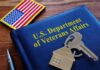 Smart Glasses For Vets – Strings Attached? VA folder with house keychain and US flag patch on wooden desk