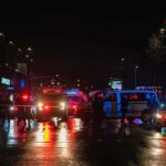 School Riots Turn Brutal Overnight Nighttime police scene with flashing lights on a wet city street