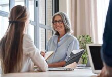 Eligibility Void Ignites League-Wide Firestorm Smiling woman with gray hair talking in a modern office