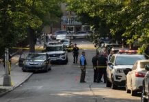 Young Dad Vanishes After Browns Game Police officers secure a residential street with patrol cars and yellow tape