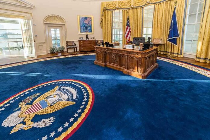 shutterstock_387330868 Oval office with wooden desk and blue presidential seal rug