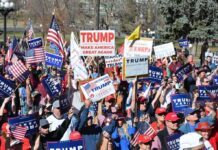 “I’m a radical. I’m extremist” – Trump Rally Speaker Tim Teufel, Christian Jones, and Nash the Slash among a crowd at a political rally holding signs and flags