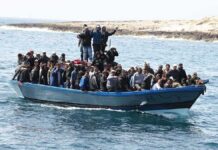 Night Crossing Turns Into Horror- 139 Dead Crowded blue boat at sea with Ivan Morales Jr., Andreas Hestler, Isaiah Frey, Christian Jones, and Teddy Williams among passengers